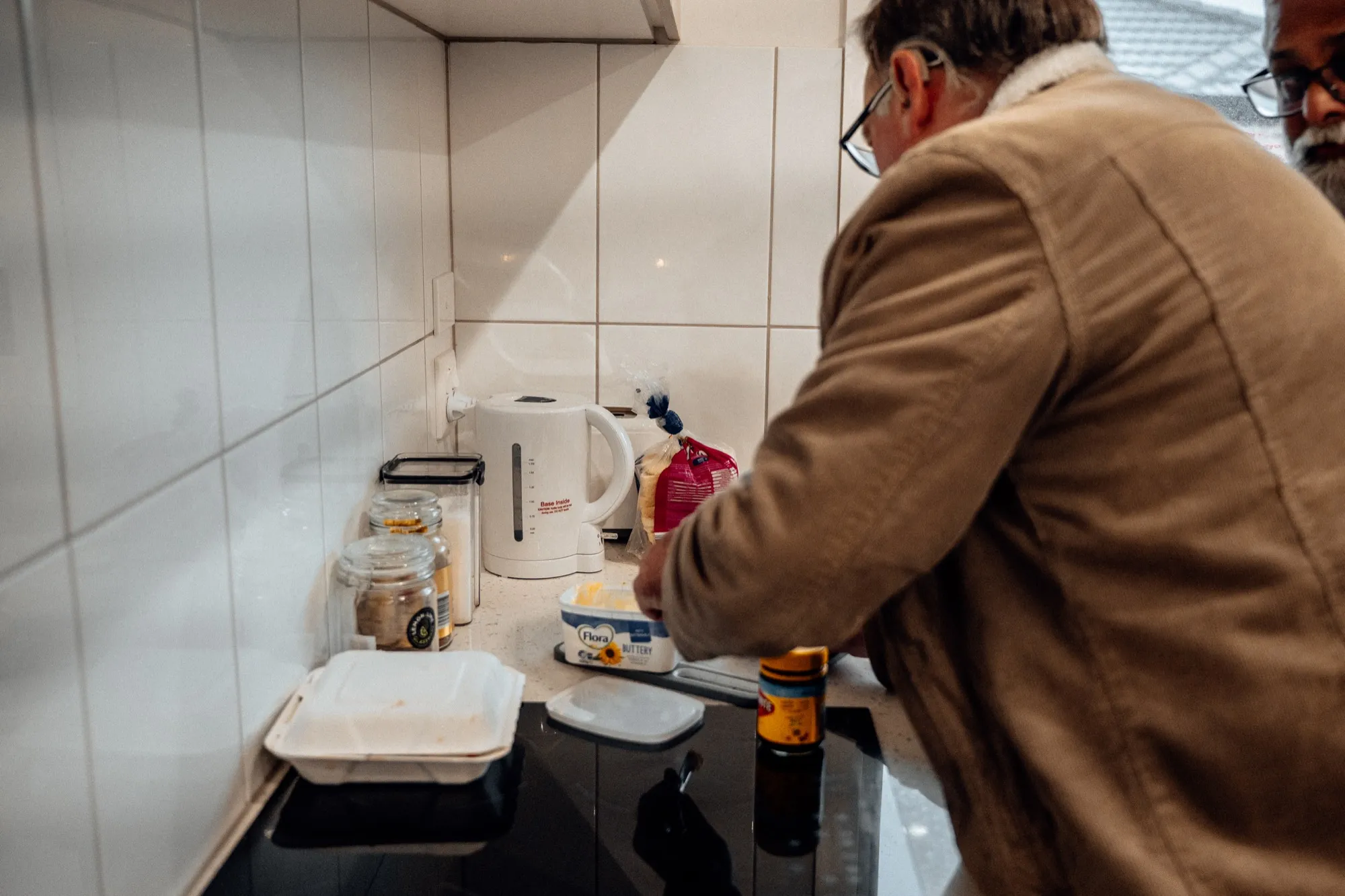 A participant preparing food in the kitchen with support
